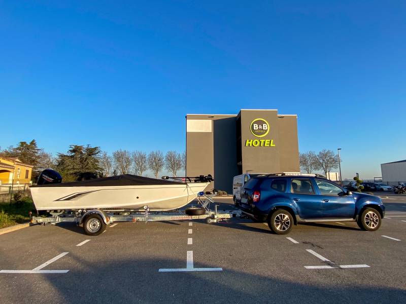 Un véhicule avec remorque stationné sur le parking de l'hôtel B&B Valence TGV Romans à Alixan